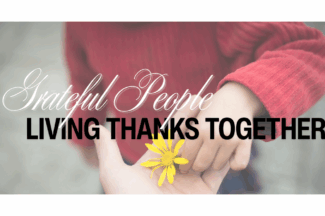 Grateful People: Living Thanks Together. A child places a flower into an adult's hand.