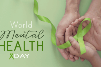 Text: World Mental Health Day. Image: two sets of hands cradling a light green awareness ribbon.