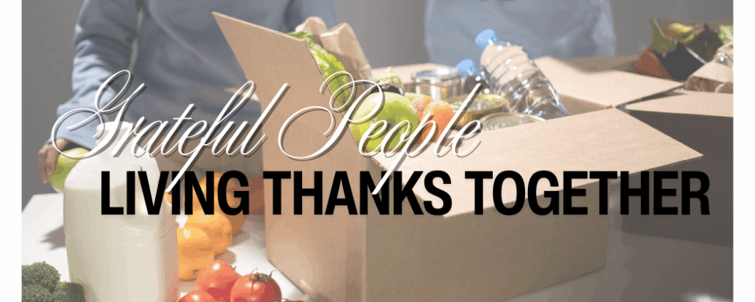 Grateful People: Living Thanks Together. A box of food donations sites on a table with two volunteer s in the background.